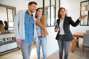 Two people review a home inspection checklist in the kitchen of a house during daylight.