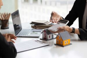 Homeowners review an insurance policy beside storm photos, receipts, and a household inventory checklist.